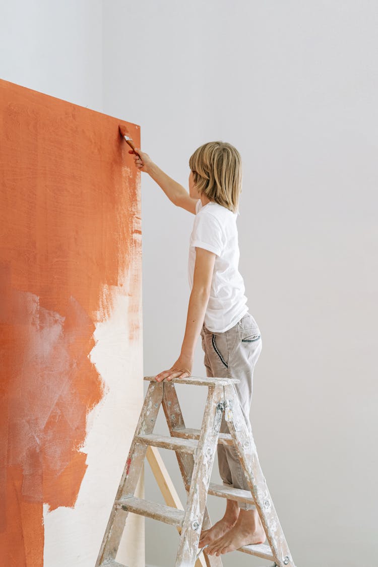 A Boy Painting A Wall 