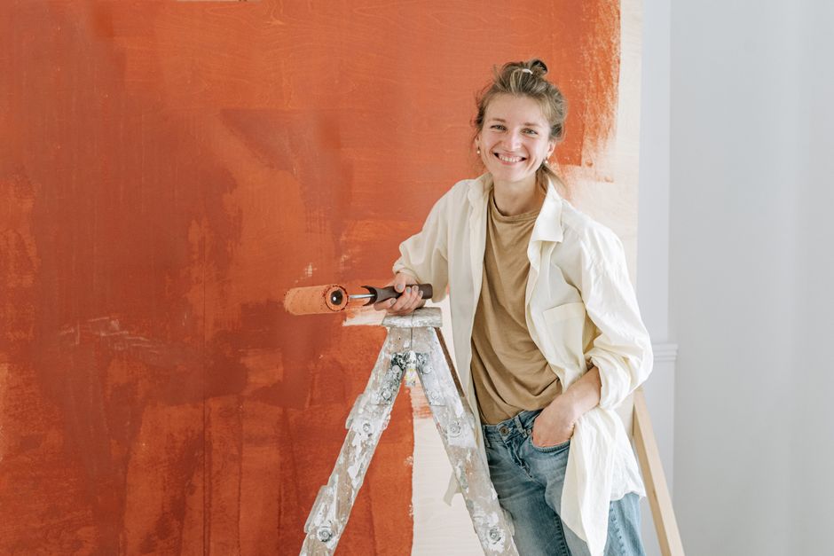 Painter figuring out how to price painting jobs while rolling paint onto a wall