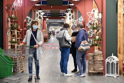 Four women shopping with face masks during holiday season in a decorated mall in Rizza, Italy.