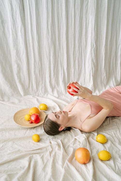 Free A Woman Holding a Pomegranate  Stock Photo