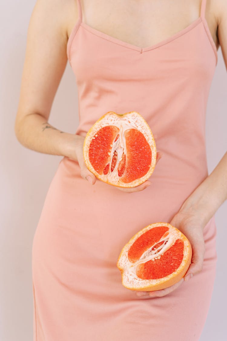 A Person Holding A Sliced Grapefruit