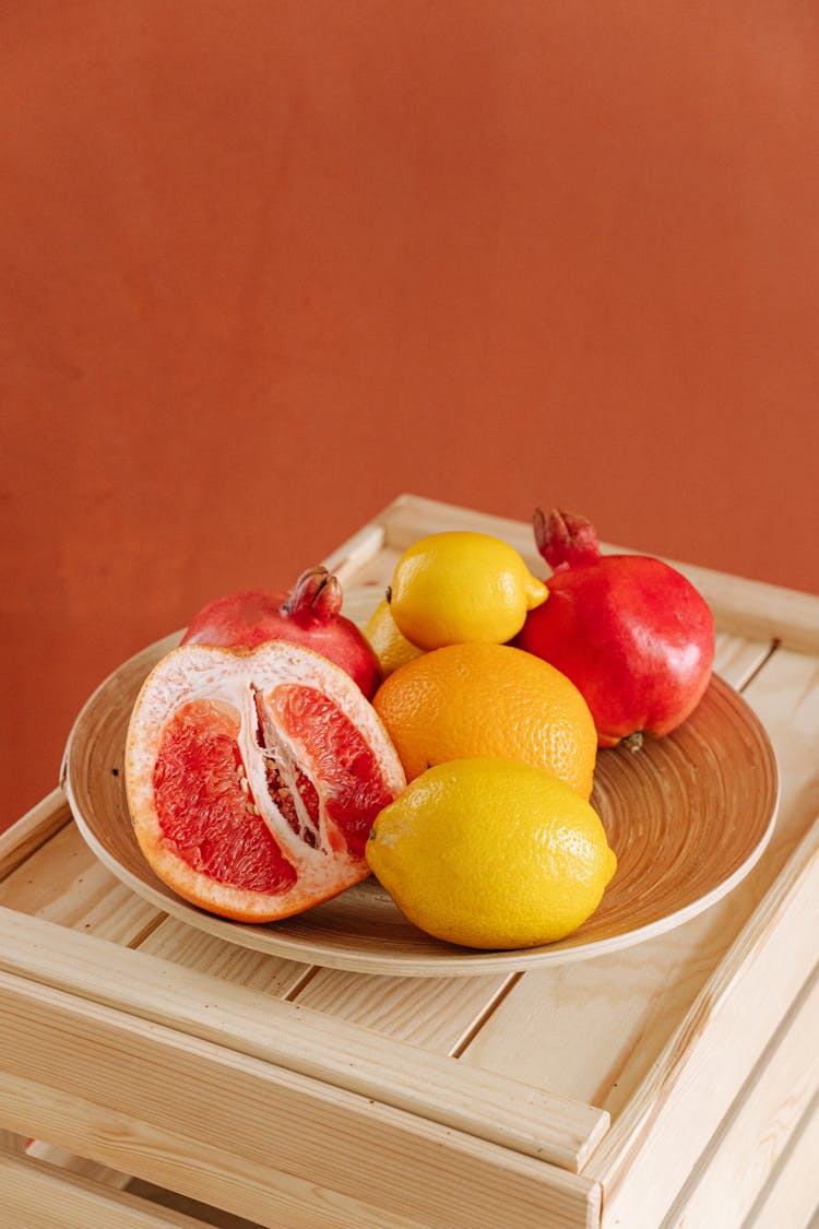 Red And Yellow Citrus Fruits On Brown Plate