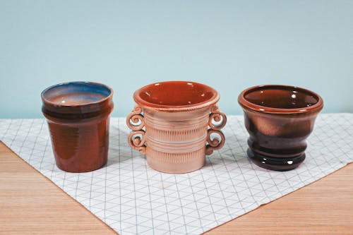 Ceramic Cups on Table Cloth over a Wooden Table