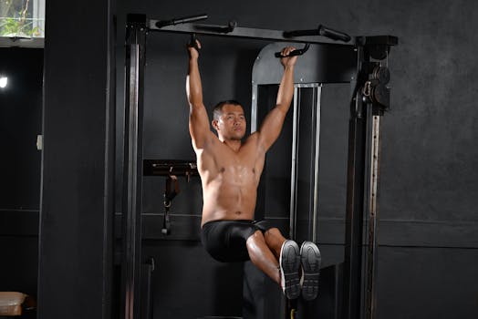 A shirtless man doing a workout with pull-up bar indoors at a gym, showcasing fitness and strength.