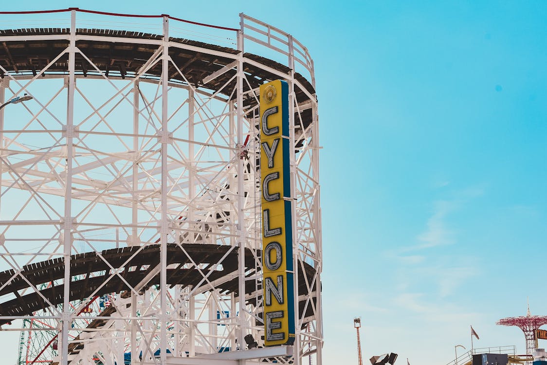 White construction of rollercoaster under clear blue sky in city park with amusements