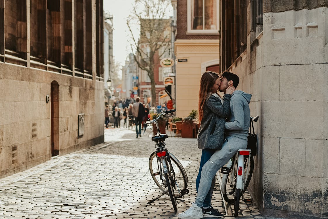 古い通りでキスする自転車とロマンチックなカップル