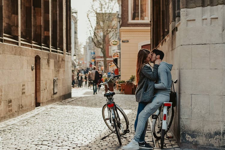 Romantic Couple With Bicycles Kissing On Old Street