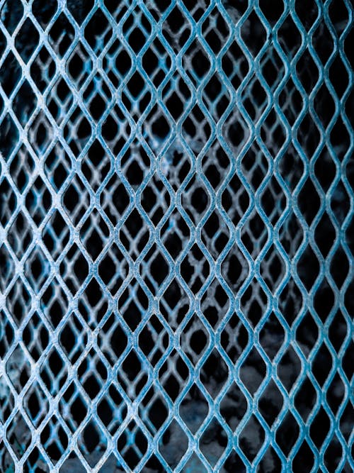 Background of folded metal net with metal grid in shape of rhomb on dark background