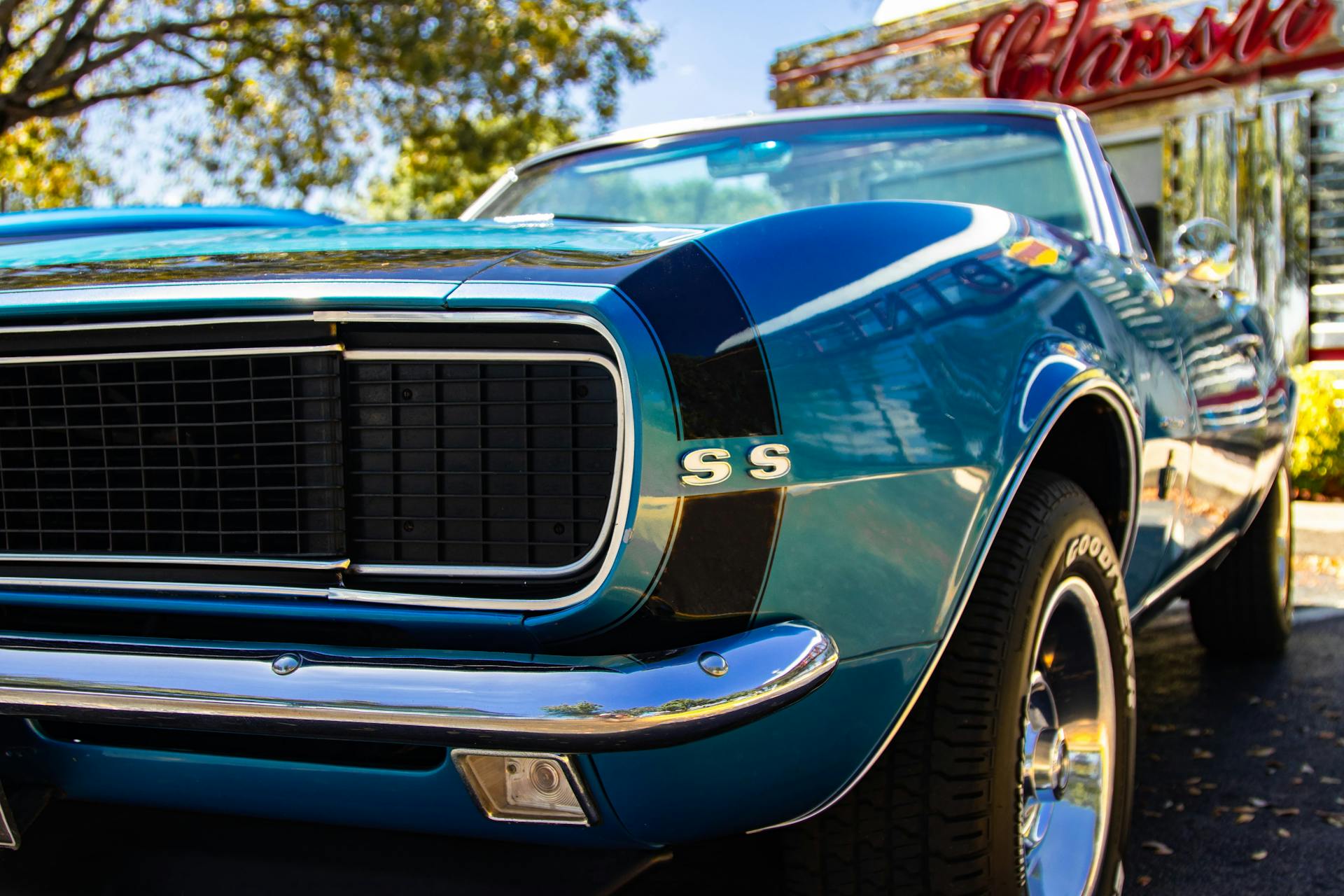 A detailed image of a classic blue Chevrolet Camaro SS showcasing its front grille and shiny exterior.