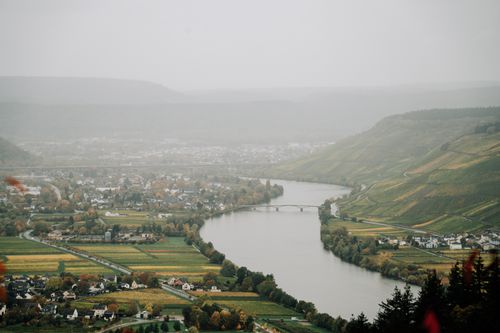 Free High angle of river flowing in highlands with small settlements on shores covered with dense haze Stock Photo