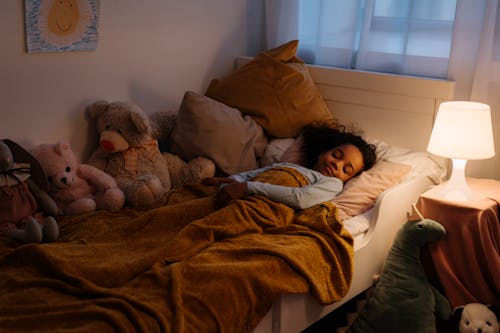 Kostenloses Stock Foto zu afroamerikanisches mädchen, bett, decke