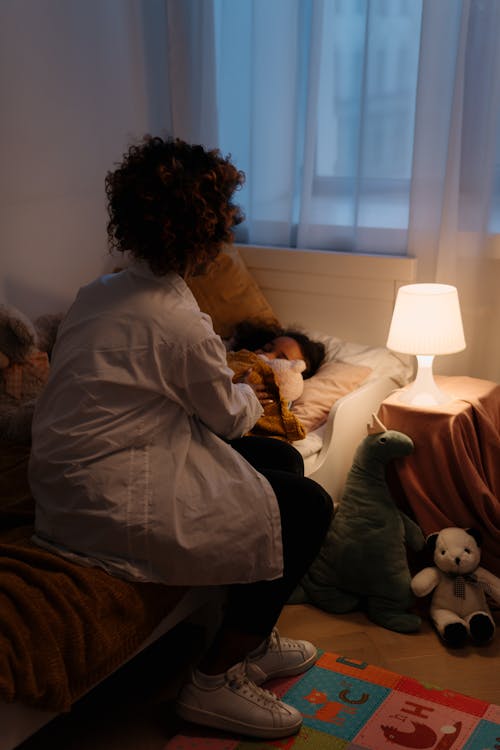 Free A Mother Putting Her Daughter to Sleep Stock Photo