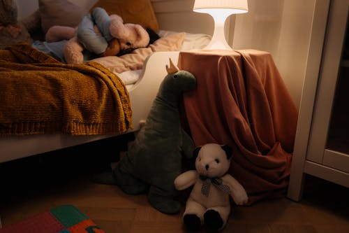 Photo of a child's bedroom setting with plush toys and soft lighting.