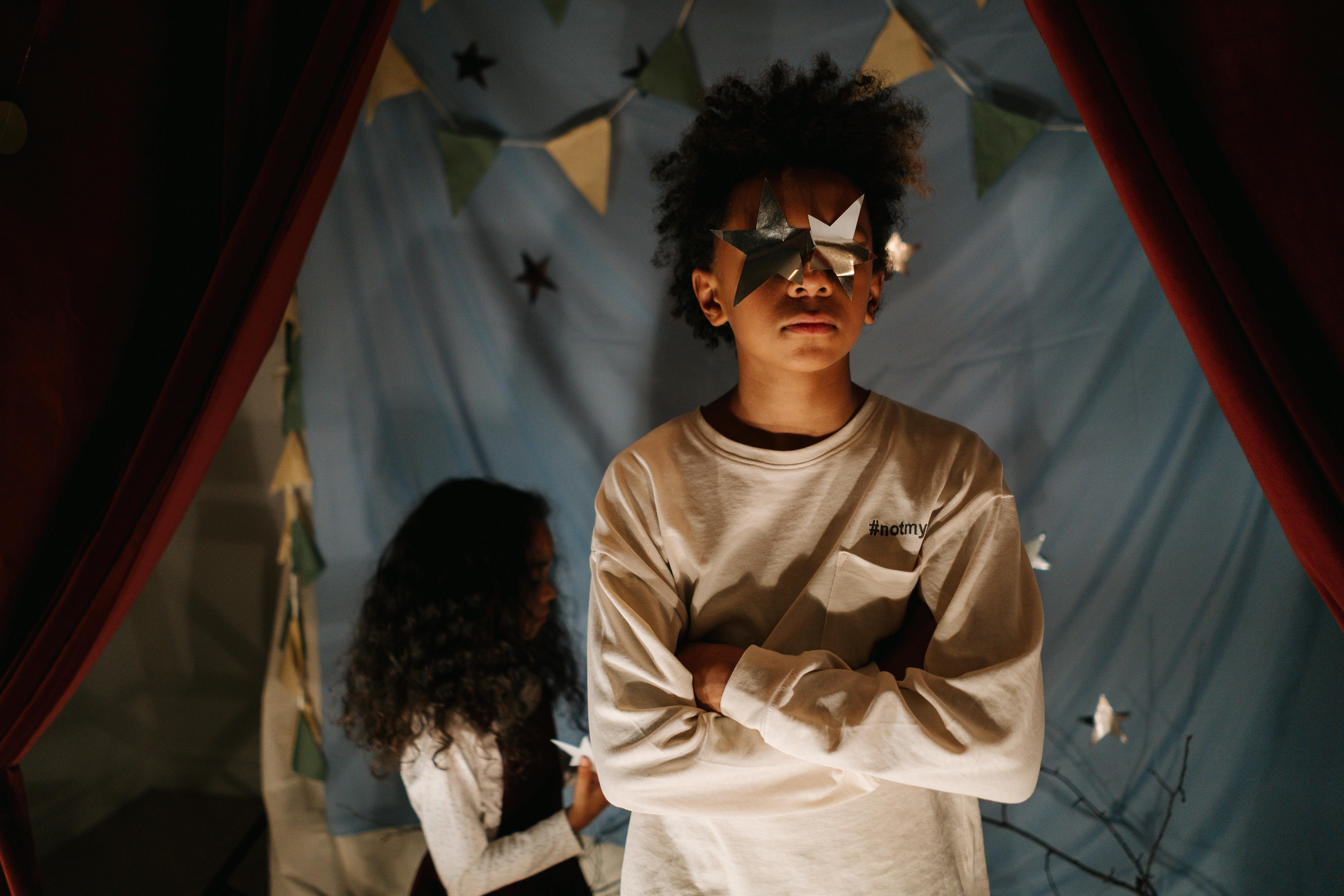 boy covering his eyes with silver stars