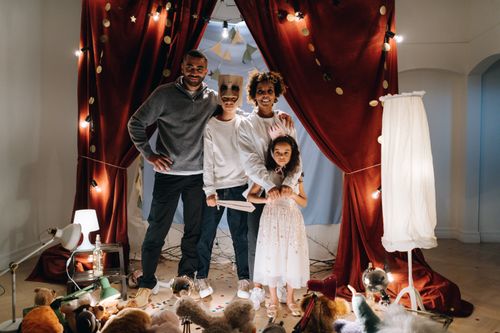 Free A joyful family enjoying imaginative play in a home theatre setting with costumes and creativity. Stock Photo