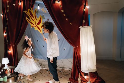 Free Two children joyfully interacting in a playful costume setting with lights and decorations. Stock Photo