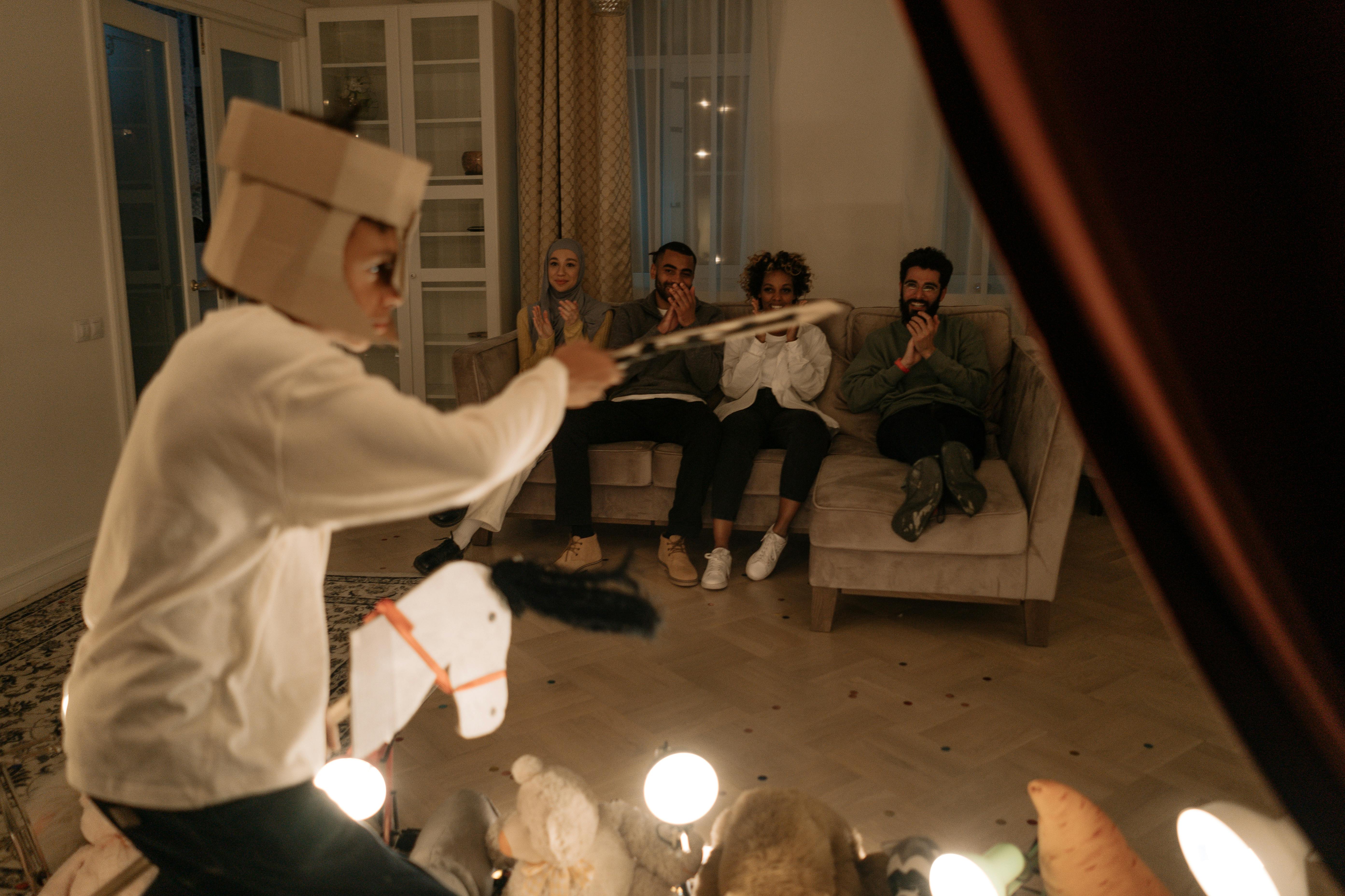 group of people sitting on couch while watchinig a boy s performance