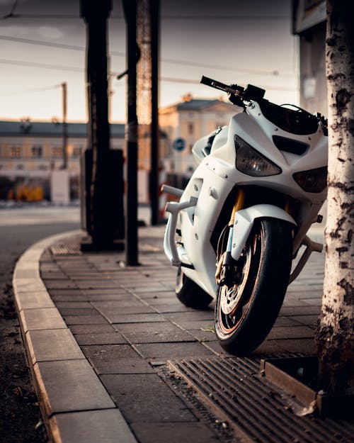 A Parked White Sports Bike on the Sidewalk