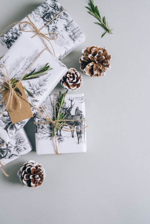 Free Stylish Christmas gifts wrapped with twine and pine cones on a gray background. Stock Photo