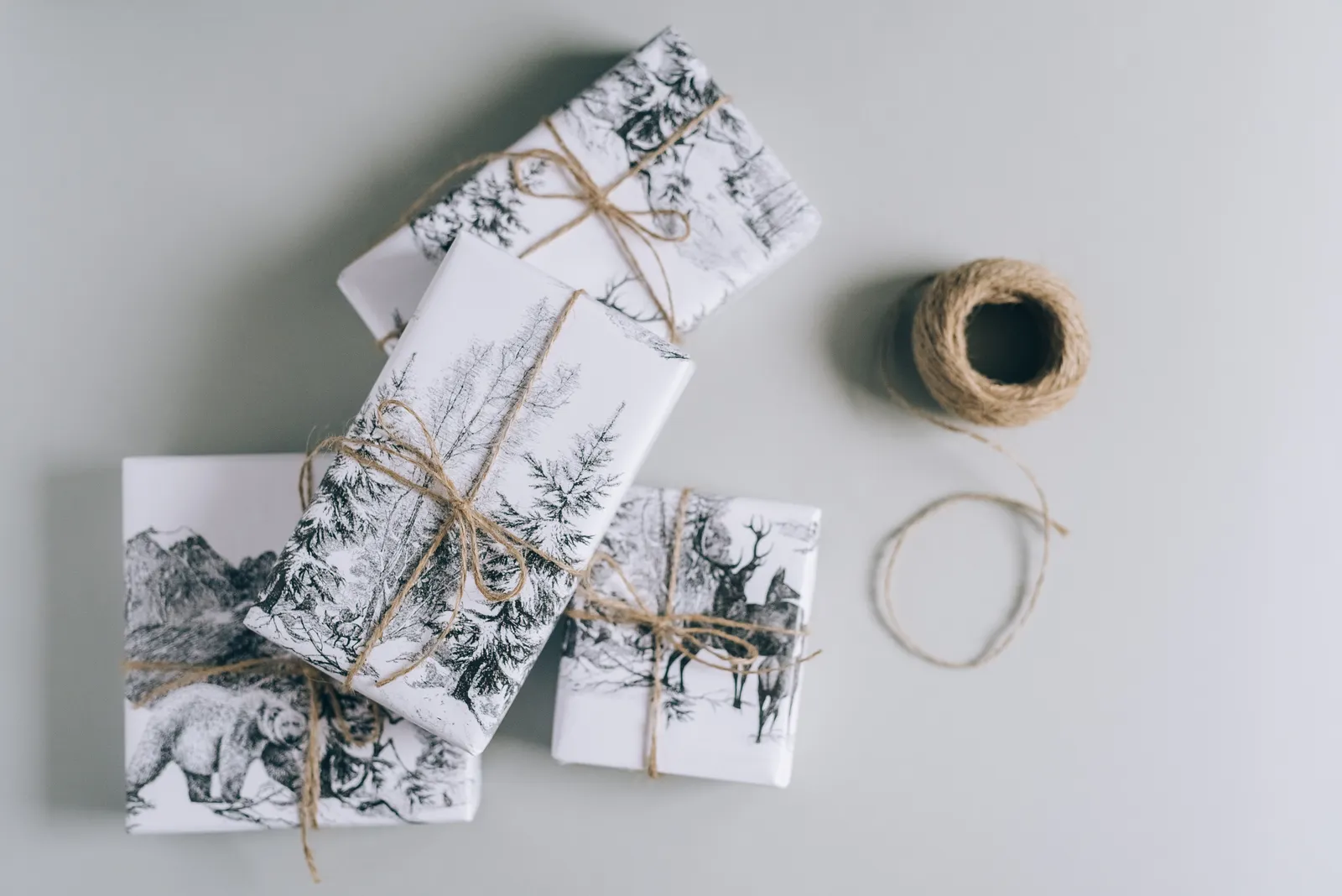 Gift boxes wrapped in nature-themed paper and twine, ready for an outdoorsy Christmas Gift boxes wrapped in nature-themed paper and twine, ready for an outdoorsy Christmas