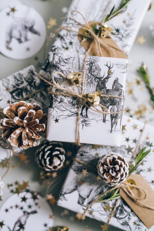 Free Beautifully wrapped Christmas gifts with pine cones and gold stars in a festive setting. Stock Photo