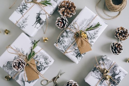 Free Elegant Christmas presents with pine cones and natural decor on a light background. Stock Photo