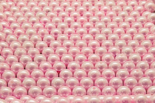 Pink and White Beads on Pink Textile