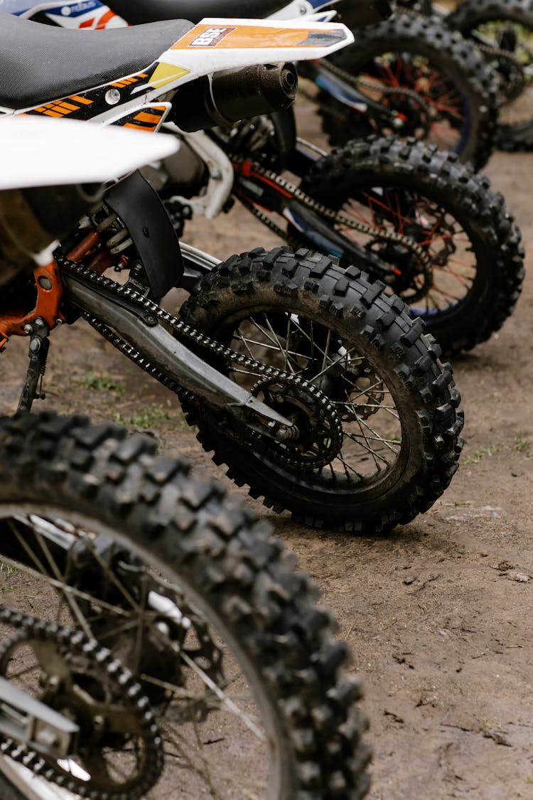 Dirt Bikes Parked On Brown Soil