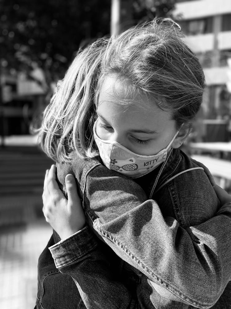 A Grayscale Photo Of Children Hugging