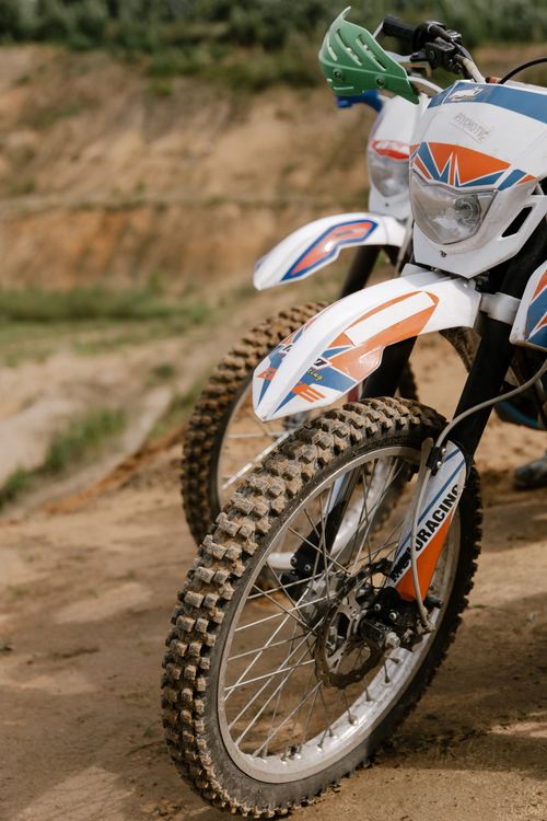 Free Close-up of parked motocross bikes on a dirt track, ready for off-road racing. Stock Photo