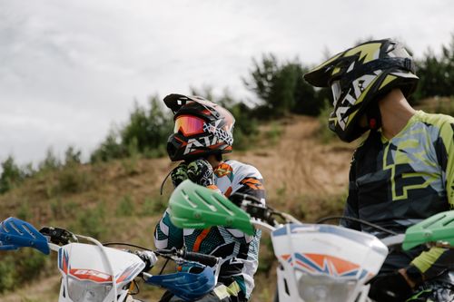 Free Two motocross riders wearing helmets prepare for an off-road race on their dirt bikes. Stock Photo
