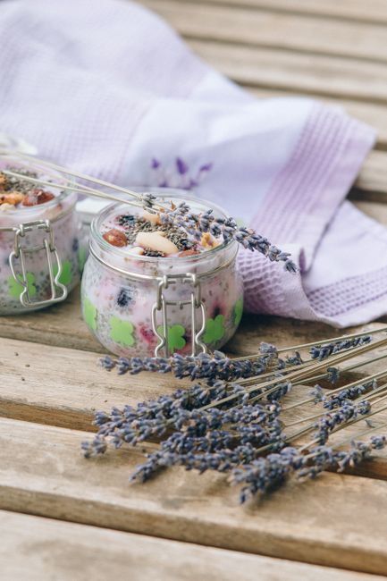 A jar of thick, creamy dairy-free coconut yogurt with a spoon lifting a swirl, topped with berries and granola.