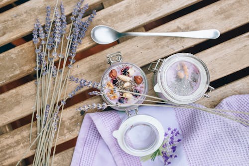 A Jar of Delicious Dessert Beside a Spoon and Lavender Flowers