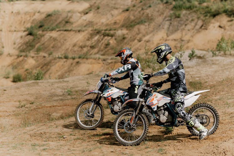 Persons Wearing Helmets Riding Dirt Bikes