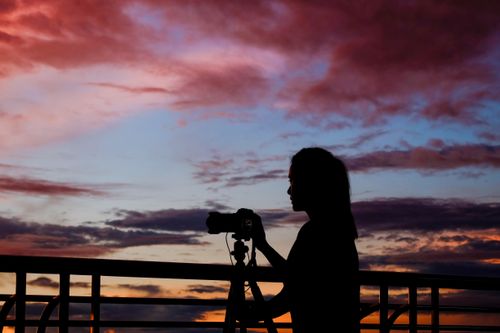 Photographer silhouetted against a dusk sky — photo by Kai-Chieh Chan on Pexels