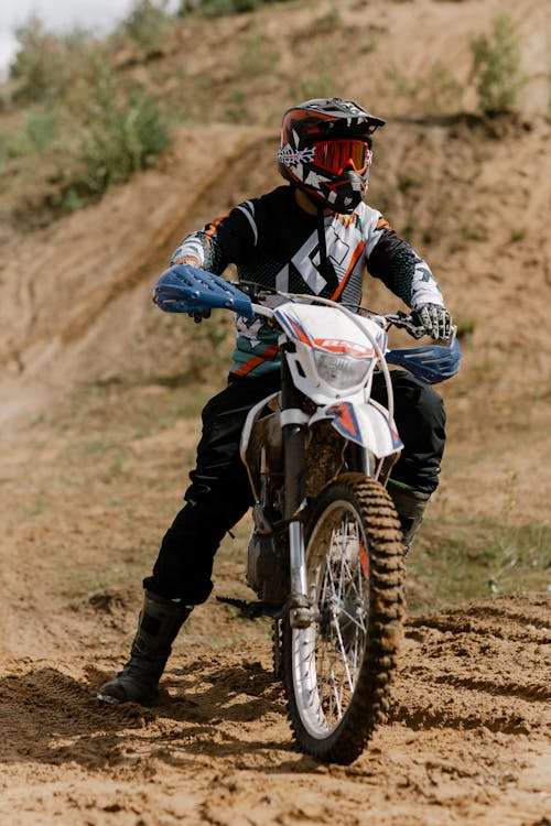 Free A Man in Motorcycle Suit Sitting on Dirt Bike Stock Photo