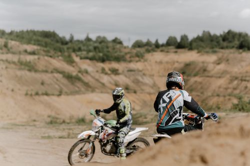 Free Two motocross riders maneuvering through challenging off-road terrain. Stock Photo