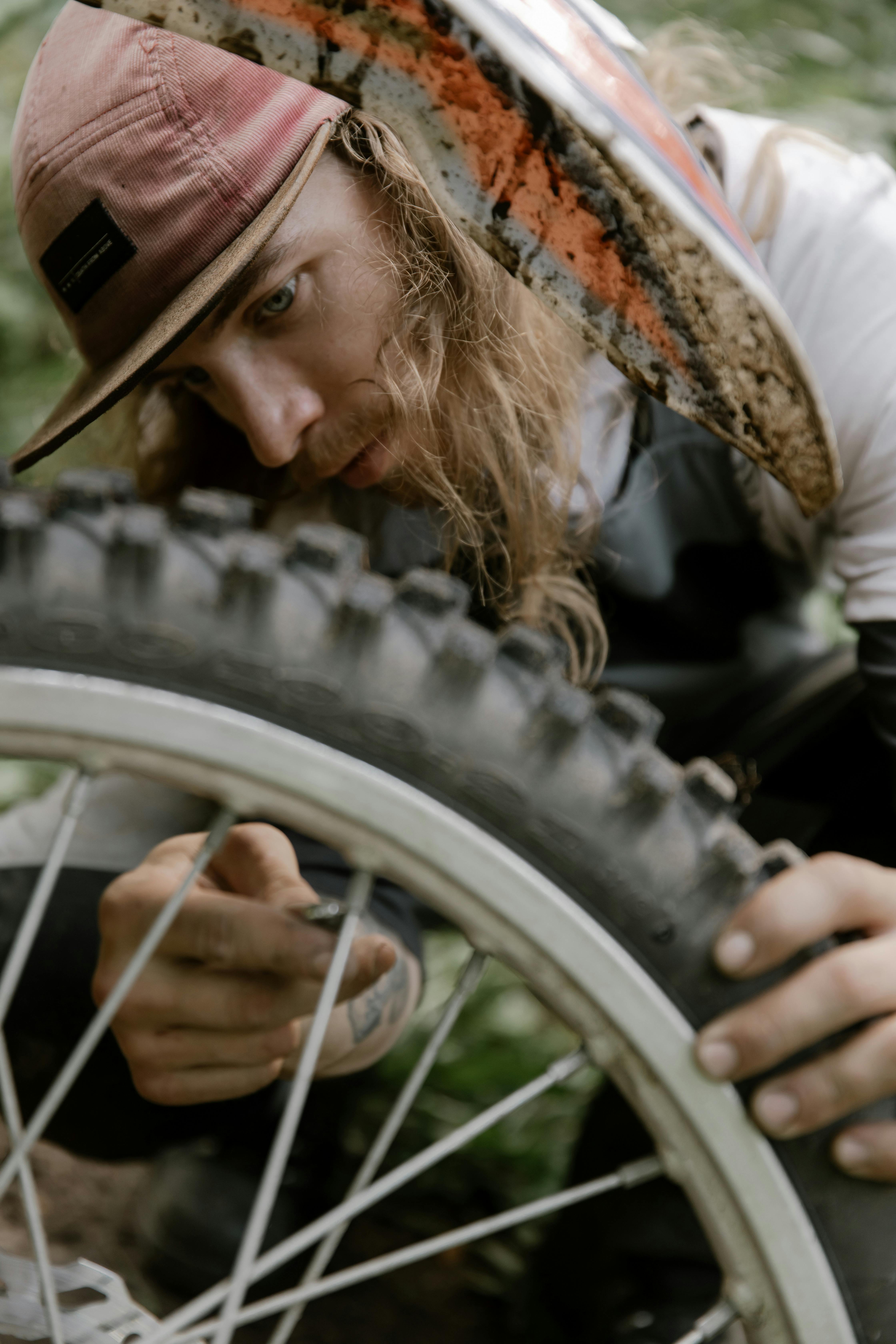 a bearded man repairing a motorcycle wheel