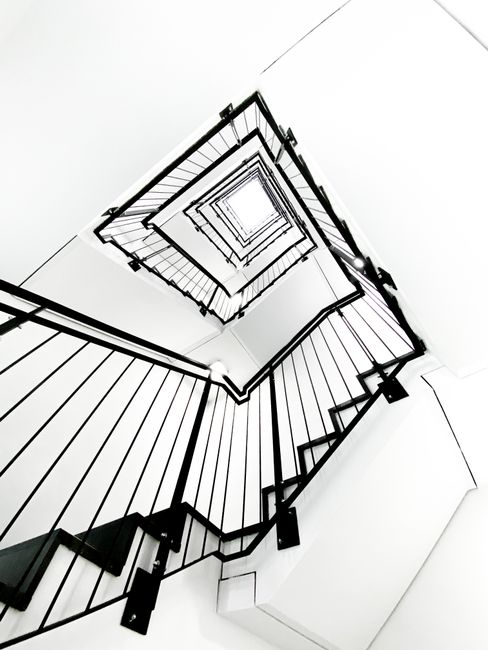 Dramatic black and white view of a spiral staircase from a low angle creates an abstract design.