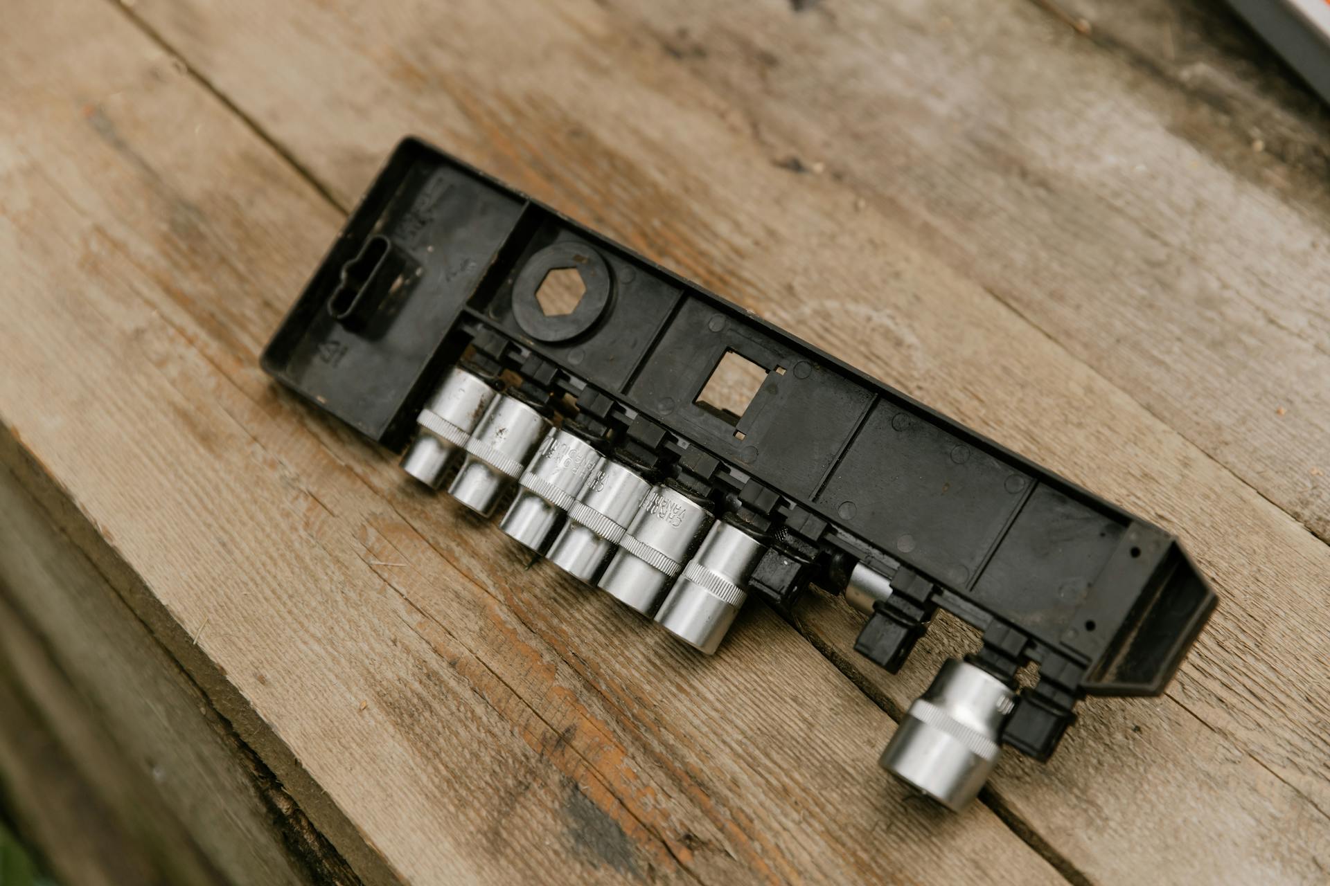 A detailed view of socket wrenches on a rustic wooden table, ideal for industrial or handyman projects.