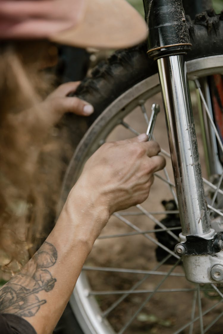 Person A Wrench Beside The Spokes