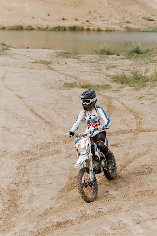 Pria Dengan Setelan Motocross Biru Dan Putih Mengendarai Motorcross Dirt Bike