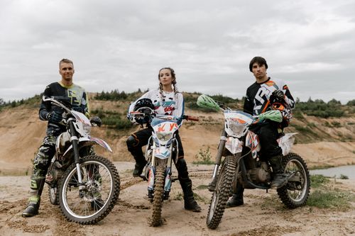 Free Three friends pose with their dirt bikes ready for an off-road motocross adventure. Stock Photo