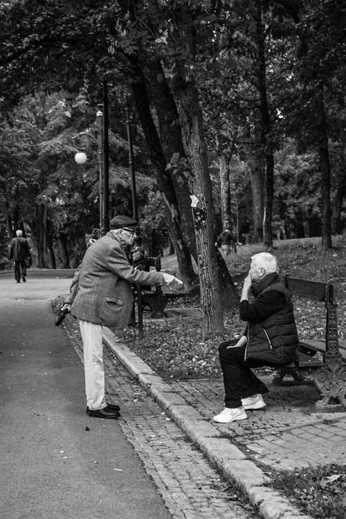 Grayscale Photo of Two Elderly People in a Park