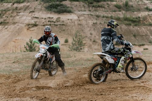 Free Two motocross racers navigate challenging off-road terrain, showcasing thrills and adventure. Stock Photo