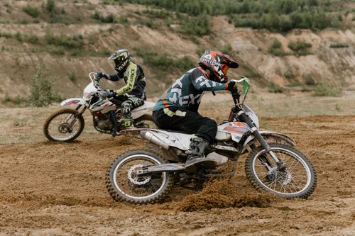 Free Exciting motocross action showcasing two riders tackling an off-road dirt track. Stock Photo
