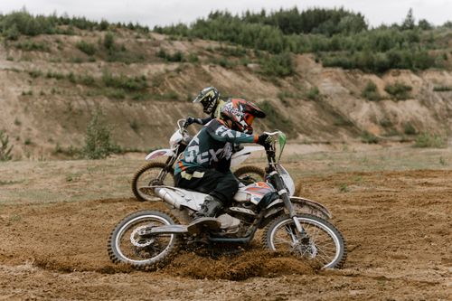 Free Dynamic image of two dirt bikers racing on a challenging motocross track, showcasing off-road skills. Stock Photo