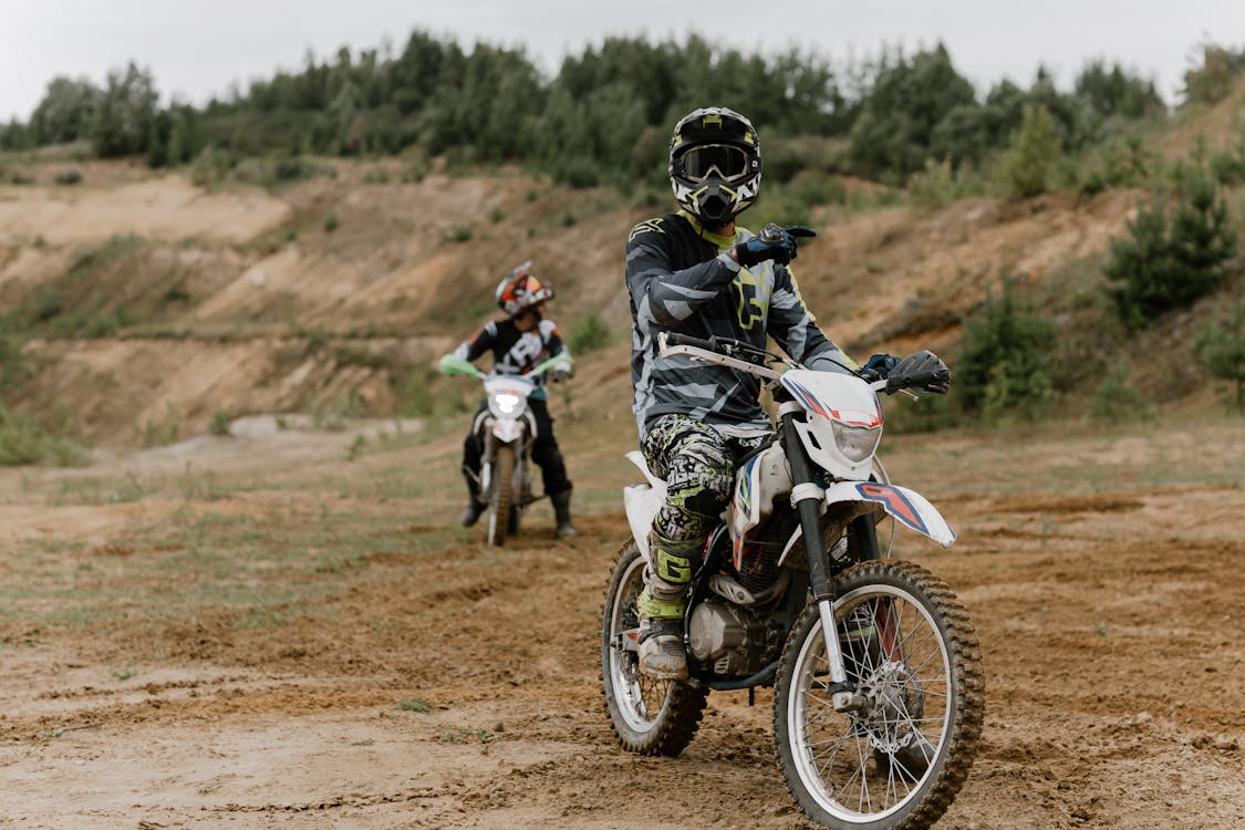 Hombre En Traje De Moto Blanco Y Negro Montando Motocross Dirt Bike · Foto  de stock gratuita