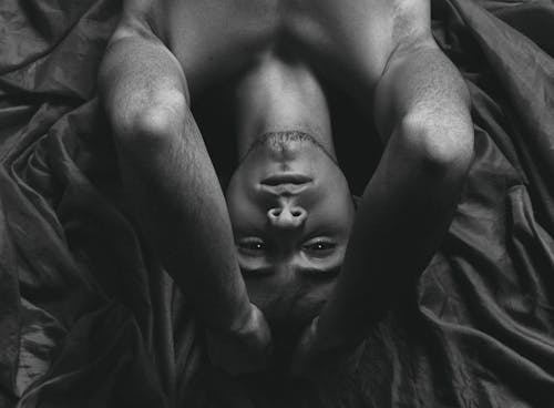 A Shirtless Man Lying Down on the Bed