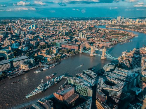 Free Stunning aerial view over London featuring the iconic Tower Bridge and River Thames. Stock Photo